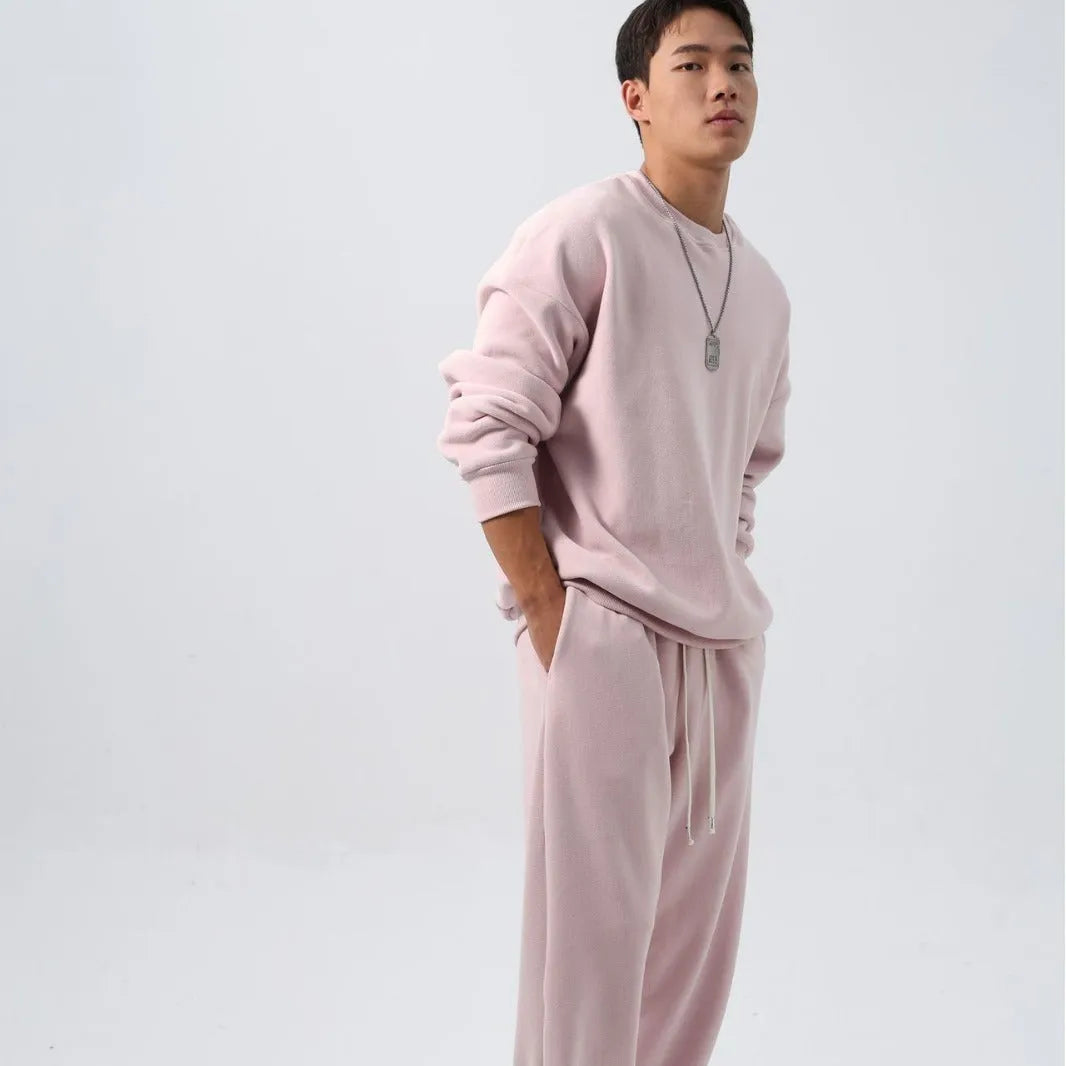 Men's loose-fit polar fleece sports suit in black, showing the long sleeve crew neck coat and matching padded trousers.