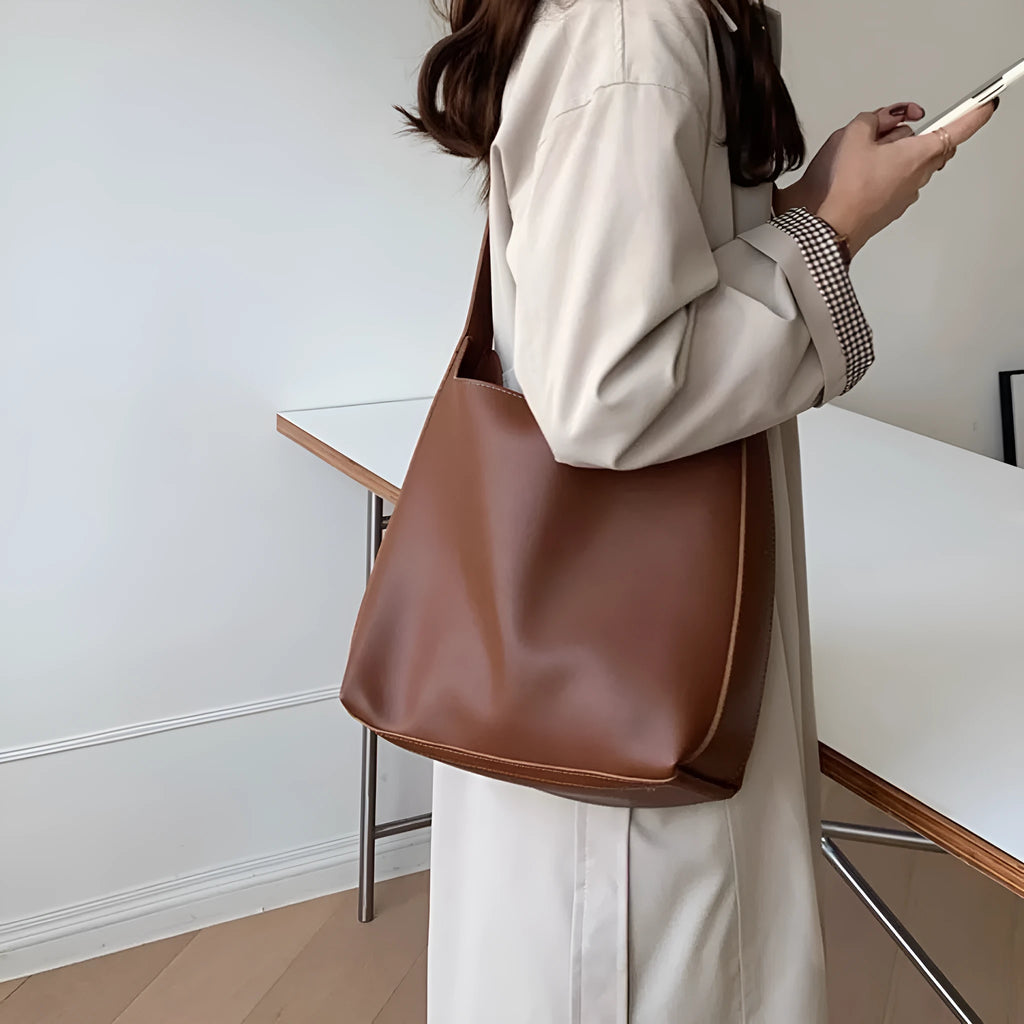 Women's soft PU leather shoulder bag with swing thread details in black or brown, showing dimensions of 28x32x12cm.