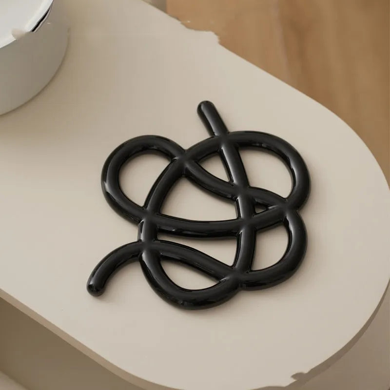 Ceramic heat proof mat in irregular shape on a wooden table