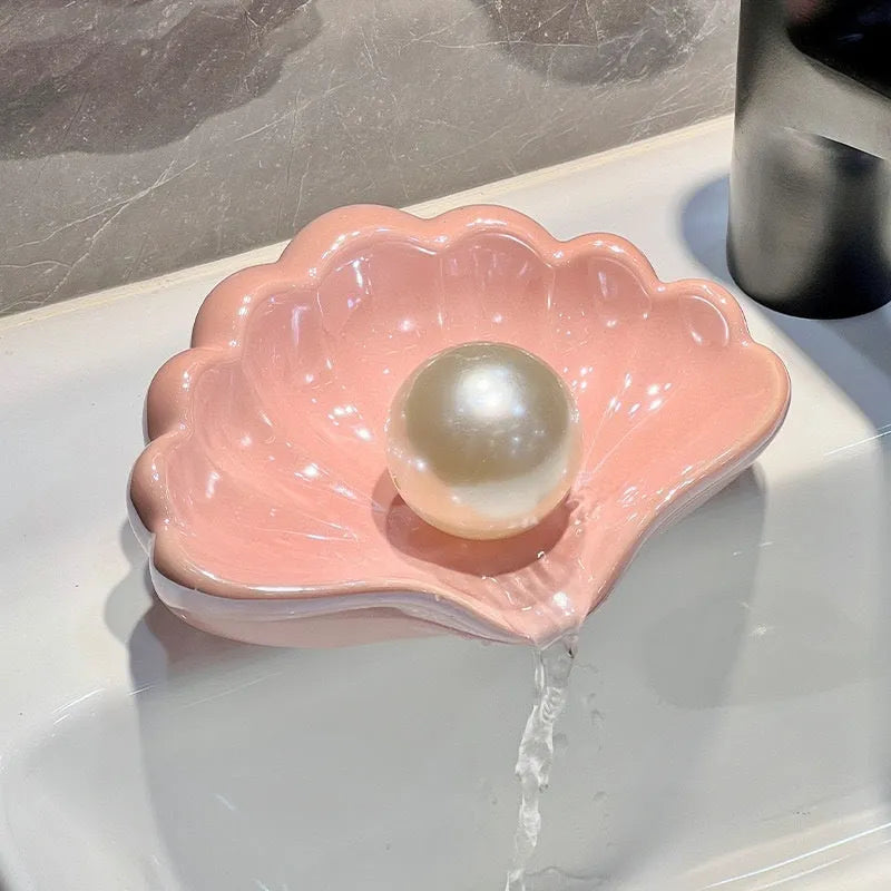 White and pink shell-shaped plastic soap dish on a bathroom countertop