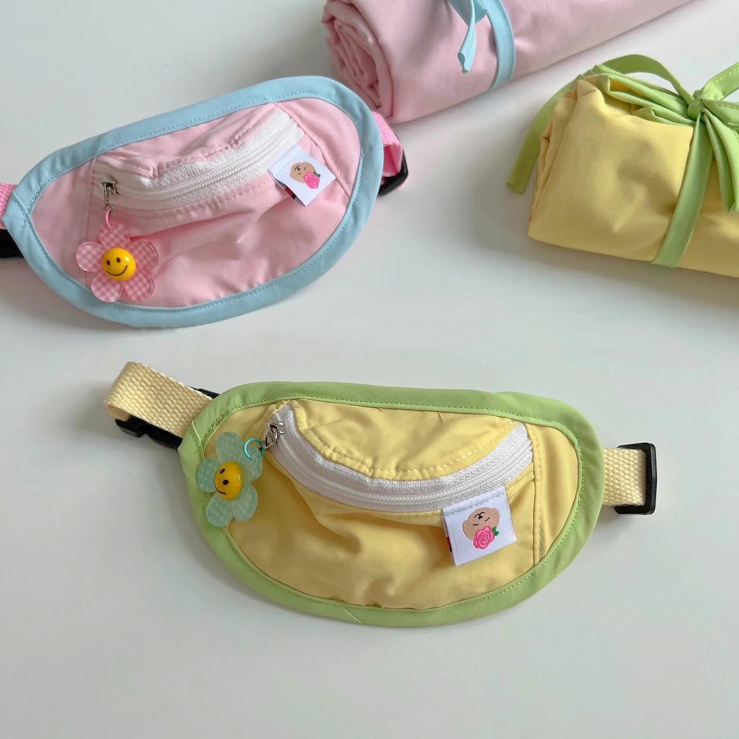 Powder blue, yellow, and green backpack-style poop bag holder for dogs and cats in S and M sizes.