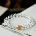 Geometric obsidian and white crystal unisex bracelet with a golden dragon bead on a wrist.