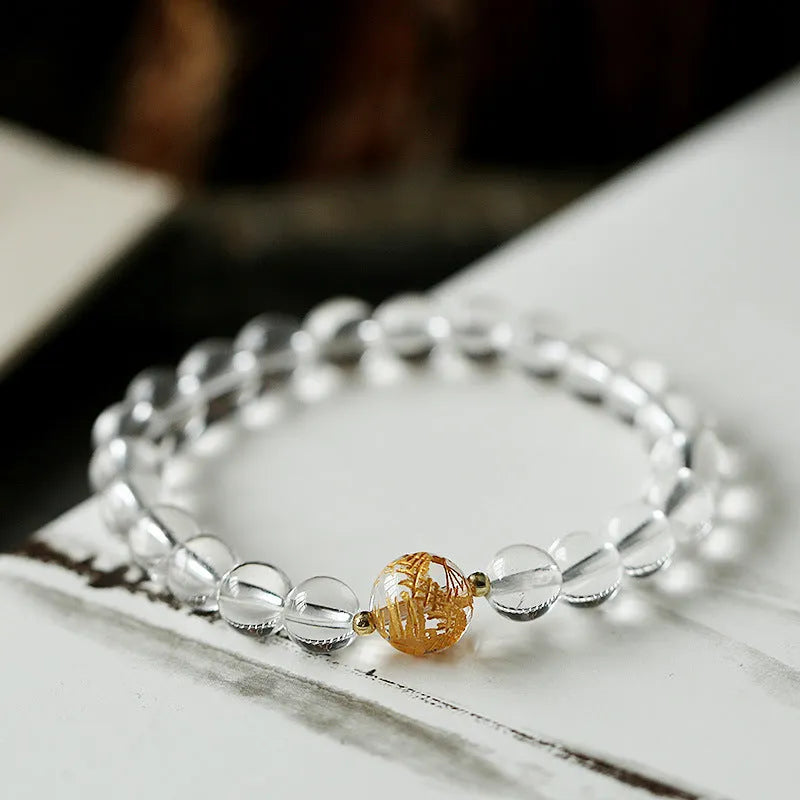 Geometric obsidian and white crystal unisex bracelet with a golden dragon bead on a wrist.