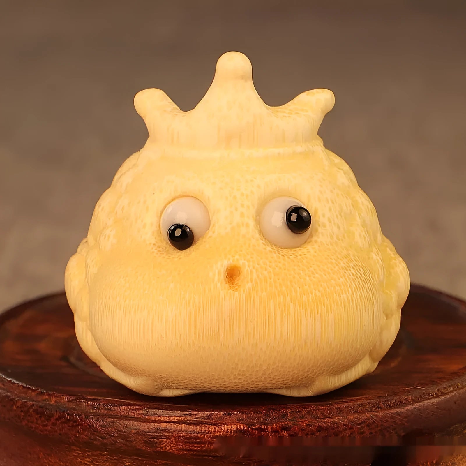 Solid bamboo carving of a cute style Crown Princess Toad ornament on display
