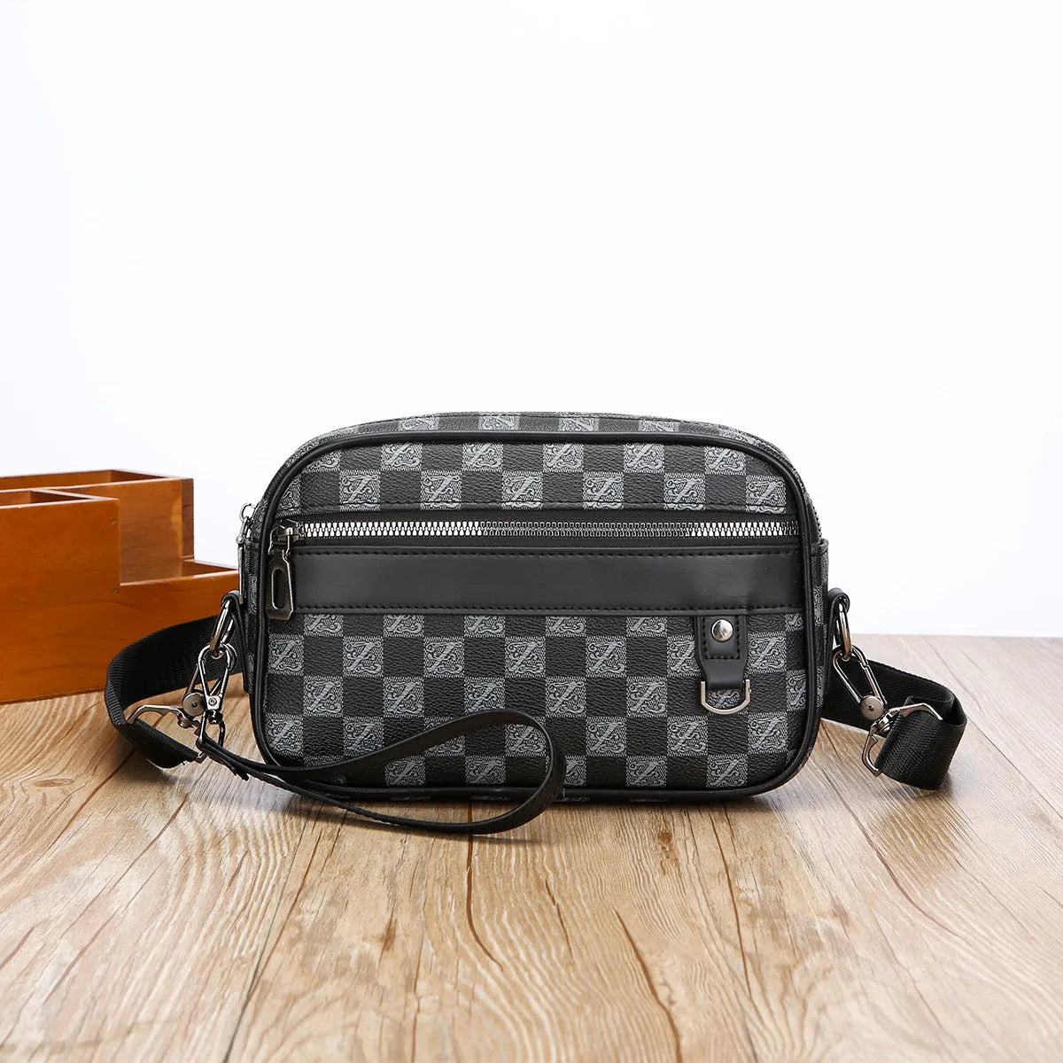 Men's black geometric pattern messenger bag showing shoulder strap and handheld carrying options