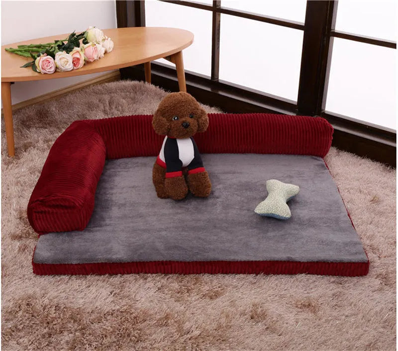 Corduroy pet sofa dog bed with bolster, shown in a grey colour on a wooden floor.