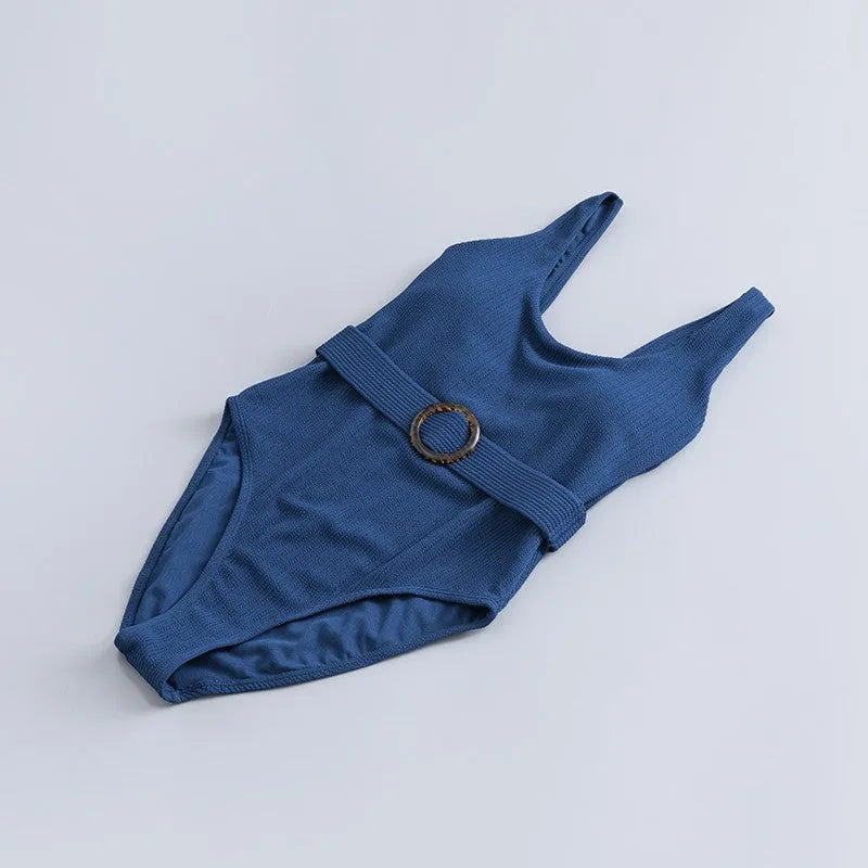 Navy blue women's one-piece triangle swimsuit with chest pads on a mannequin.
