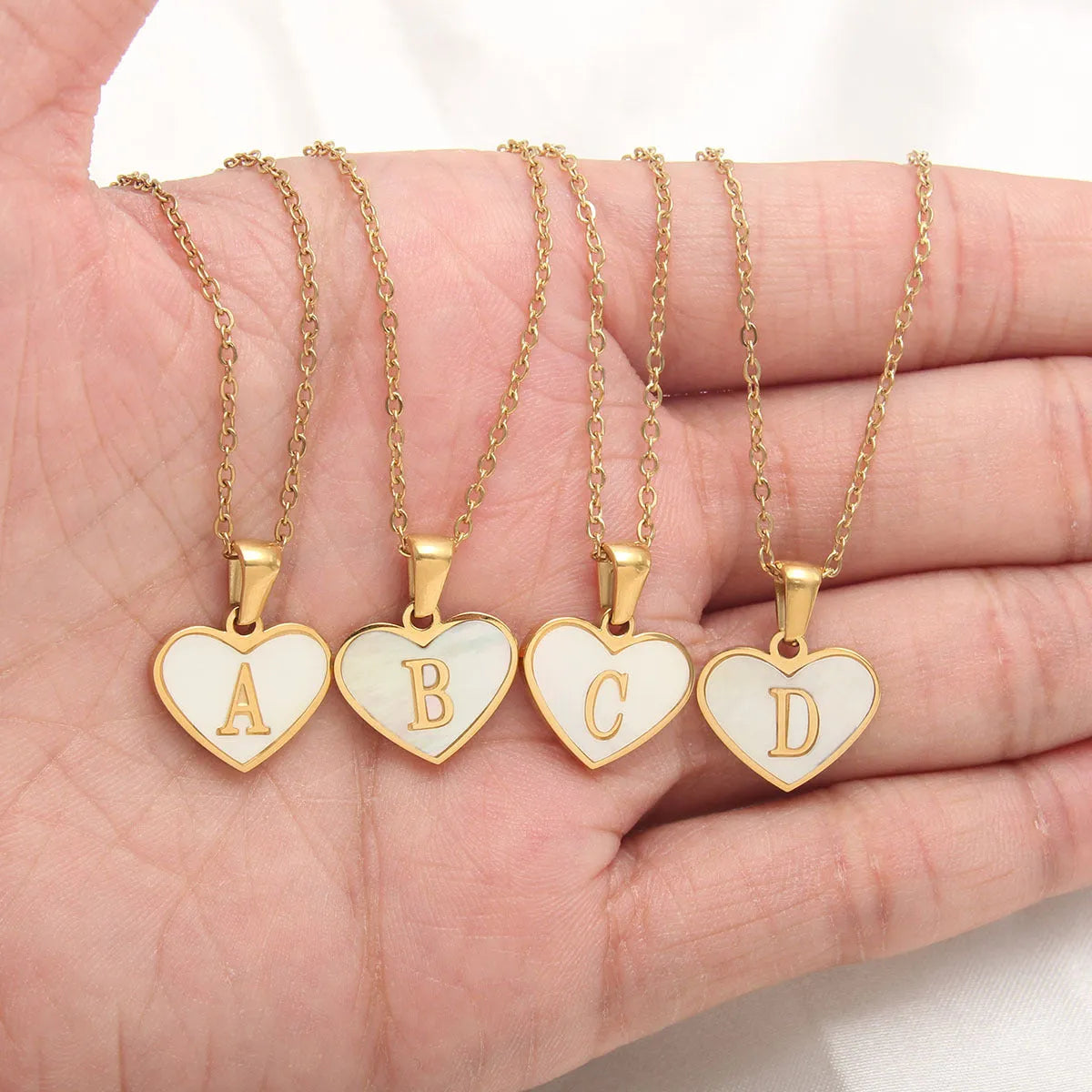 Gold plated initial necklace with white shell heart pendant and adjustable chain