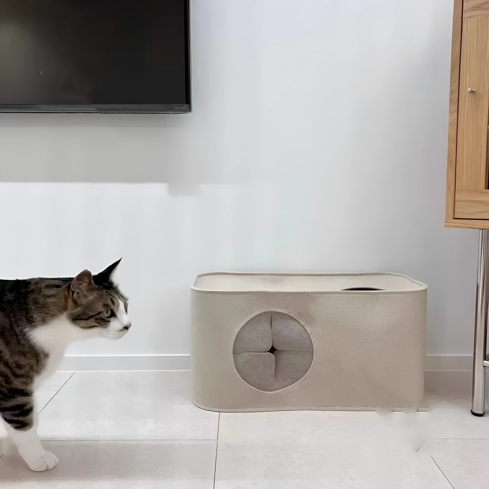 Foldable grey felt cat nest bed shown in a home setting next to a cat.