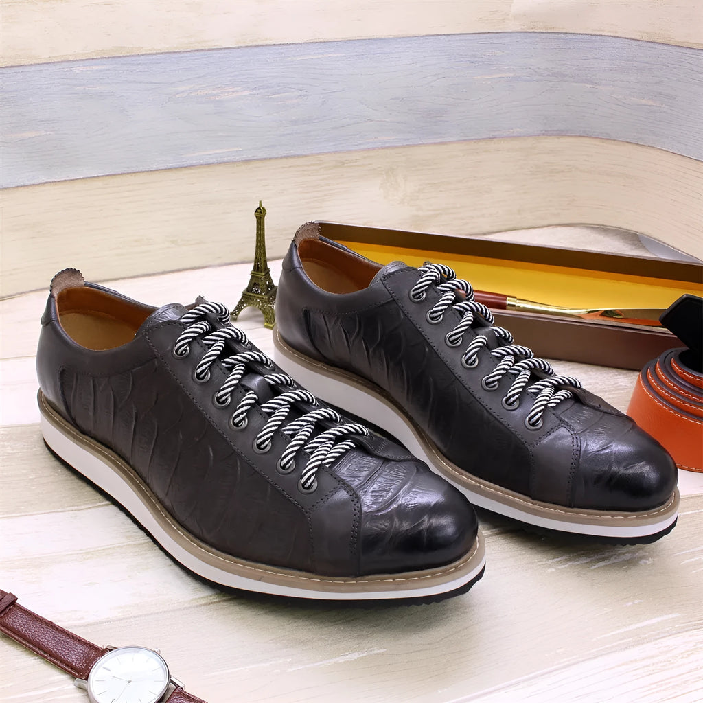 Men's handmade low-top shoes with embossed pattern detail and front laces.