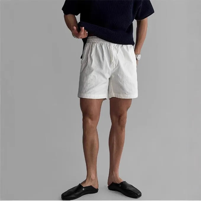 Men's loose-fit cotton sports shorts in black, shown on a white background.