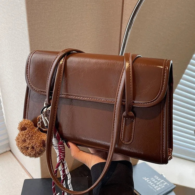 Women's brown PU Maillard shoulder bag with pendant detail, showing horizontal square shape and double straps.