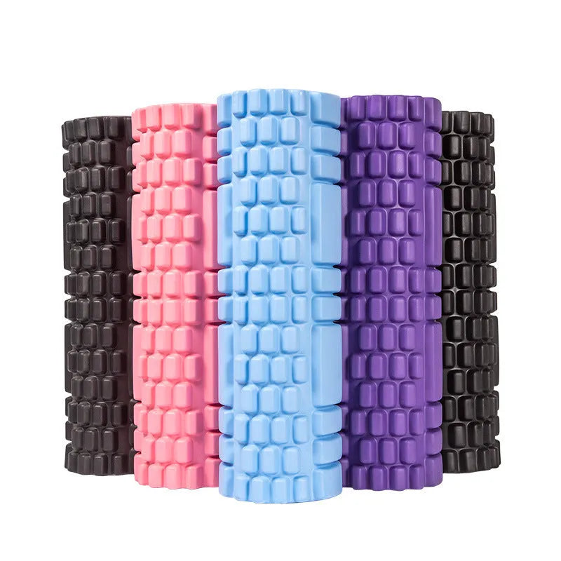 A black EVA foam roller on a floor, a fitness tool for muscle recovery and yoga.