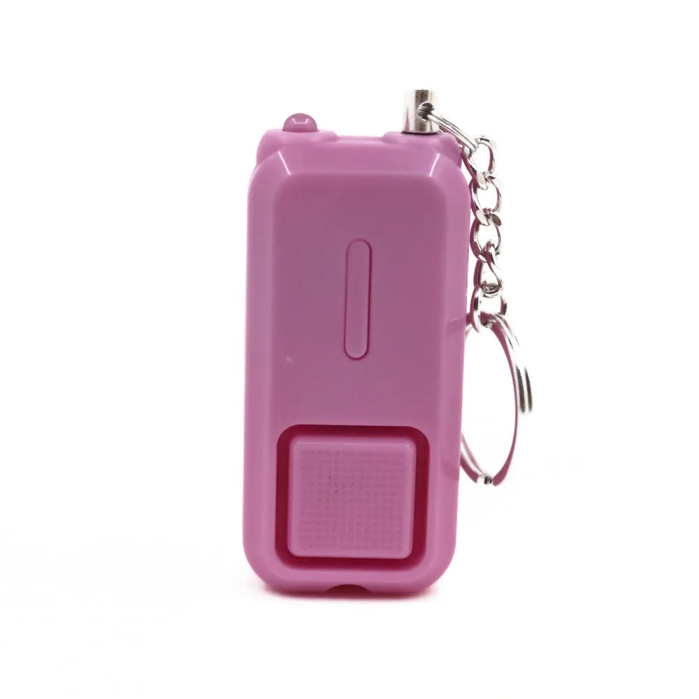 Small pink personal safety alarm on a keyring with a white box.