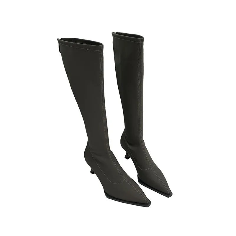 Black pointed toe women's boots with a back zipper and a stiletto heel.