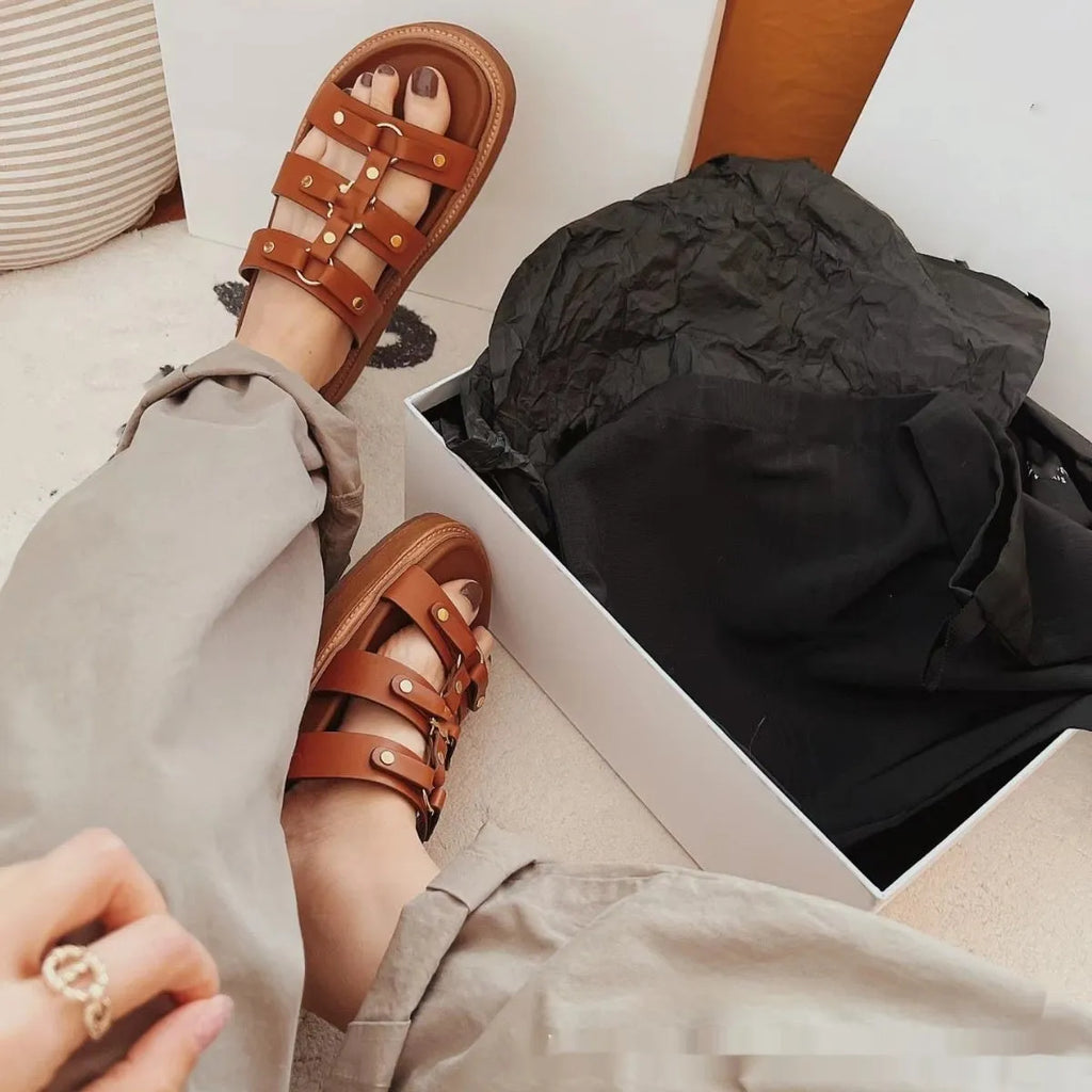 Women's brown patent leather Roman gladiator sandal slippers with crossed straps and sheepskin lining.