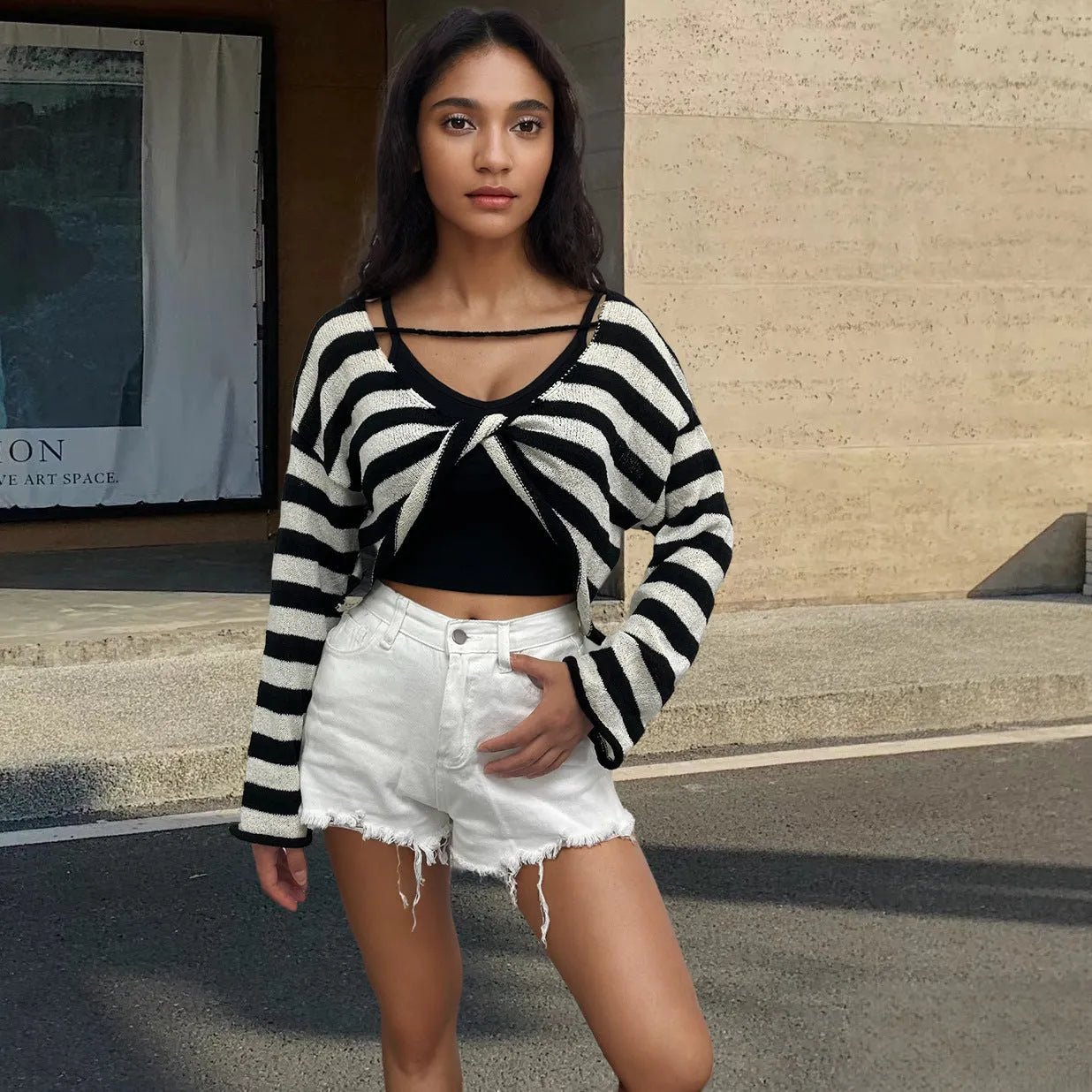 Women's black and white striped long-sleeved sweater with exposed navel front and back design.
