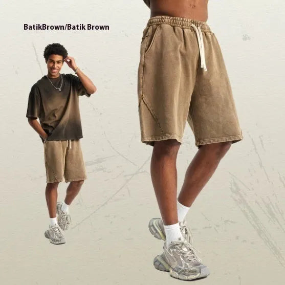 Man wearing loose-fit batik washed cotton terry shorts in a retro style with patch craft details.
