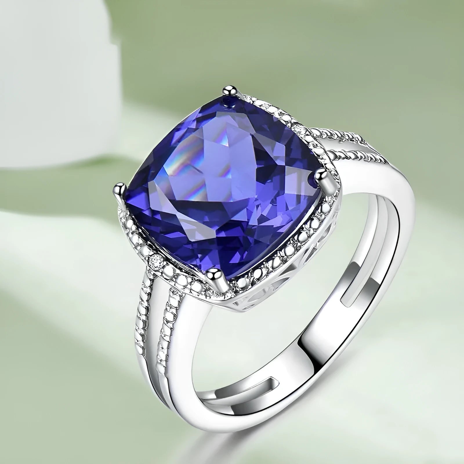 Blue tanzanite gemstone set in a sterling silver women's ring on a plain background.