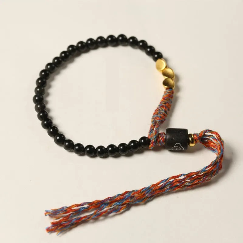 Hand-woven obsidian wrist bracelet showing 4mm width and textured strand construction