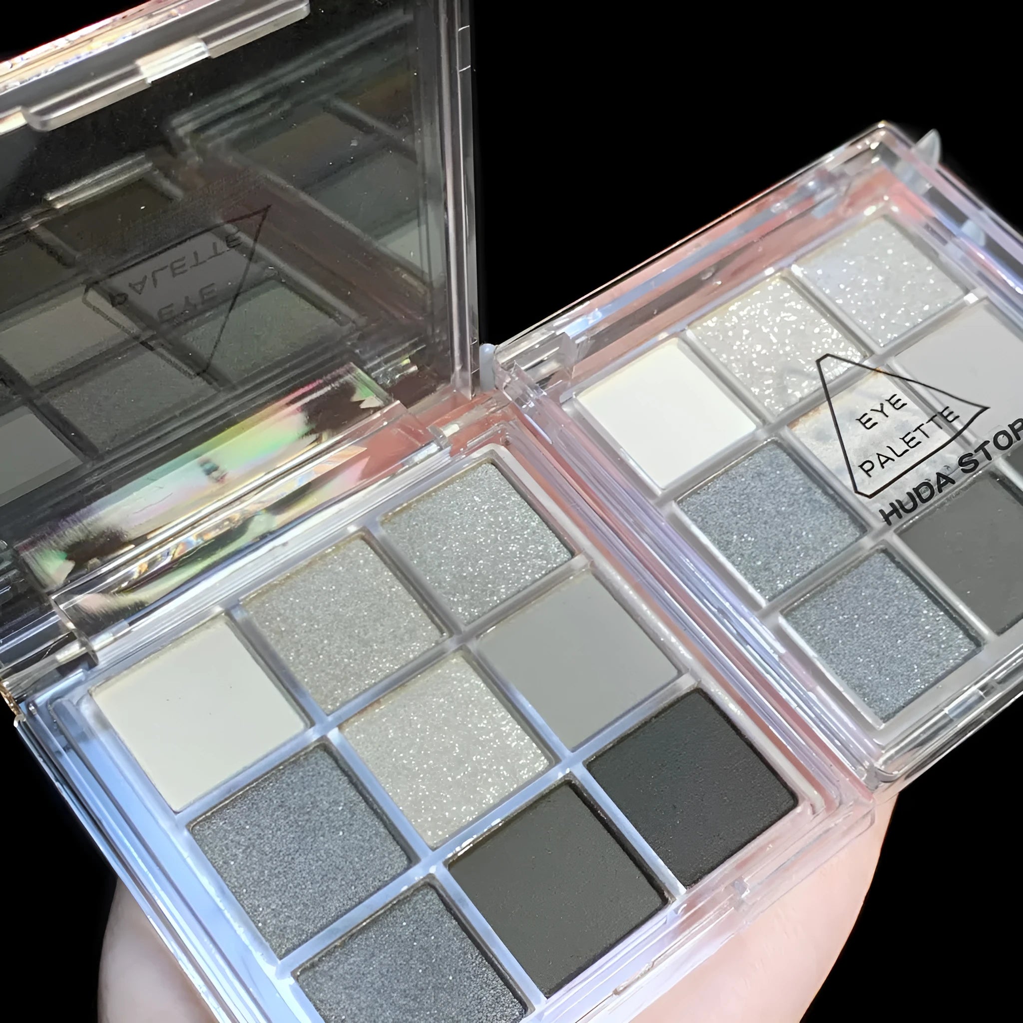 Nine-colour smoked eyeshadow palette showing white, silver, black and iron grey shades in compact case