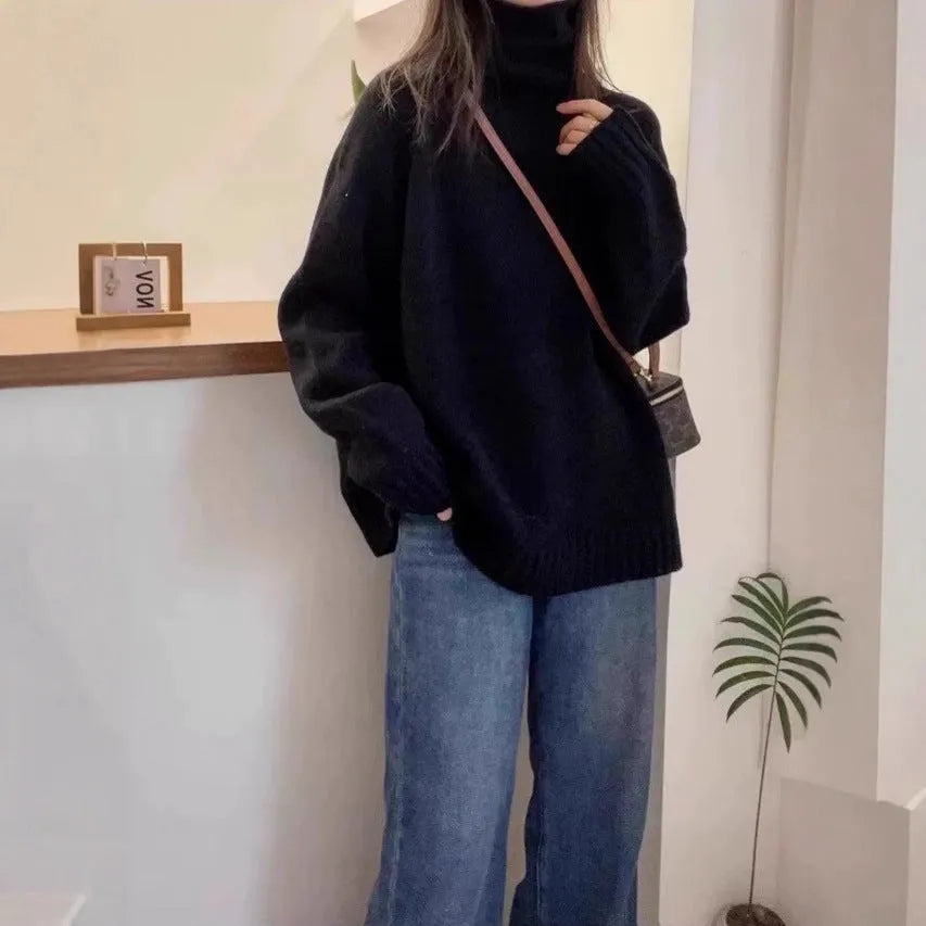 Women's loose grey turtleneck sweater with a thick, textured curling pile collar.