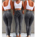A pair of distressed grey fringed jeans made from Cowboy denim fabric on a neutral background.