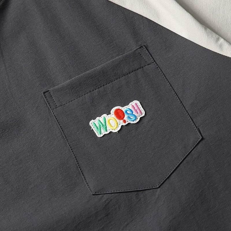 Dark grey loose fit quick-dry t-shirt with contrast raglan sleeves on a hanger.