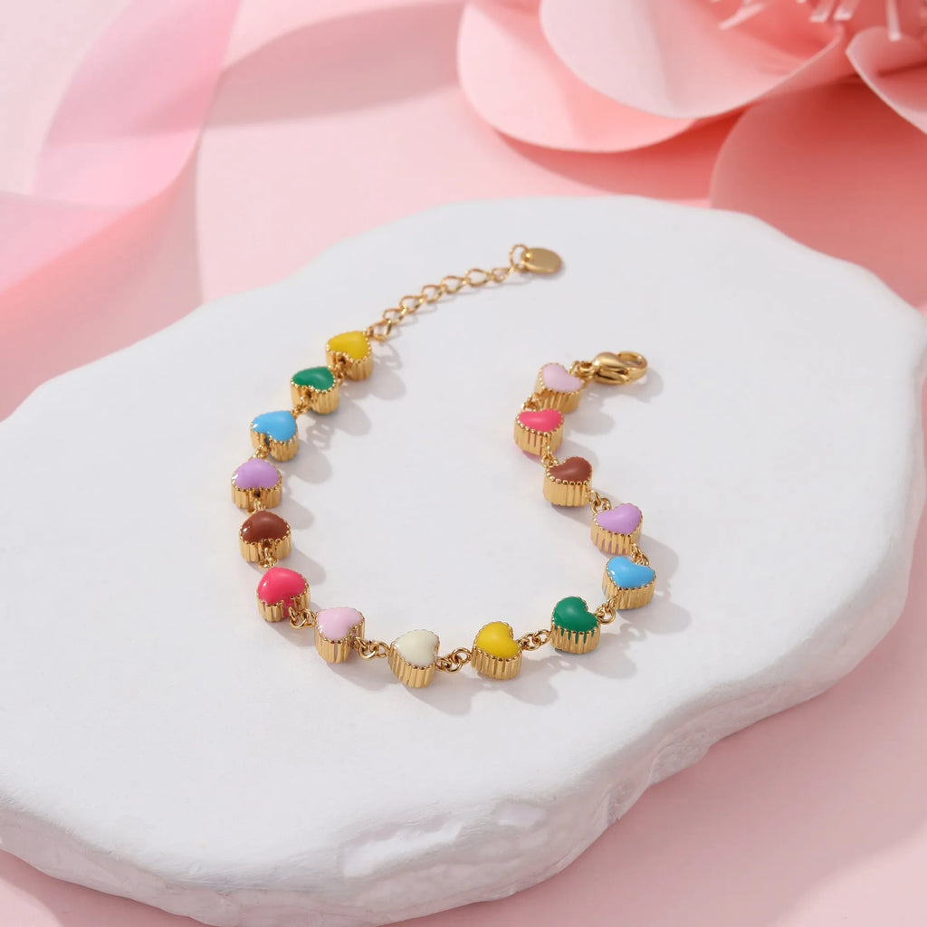 Women's stainless steel bracelet with love heart pendant featuring colourful oil finish in gold or steel colour