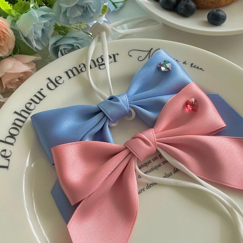 Blue princess style bow dog hair band with adjustable tension on a white background.