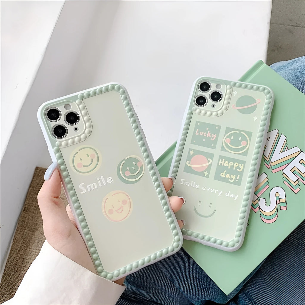 Green TPU iPhone case with a smiley face and polka dot geometric design on a table.