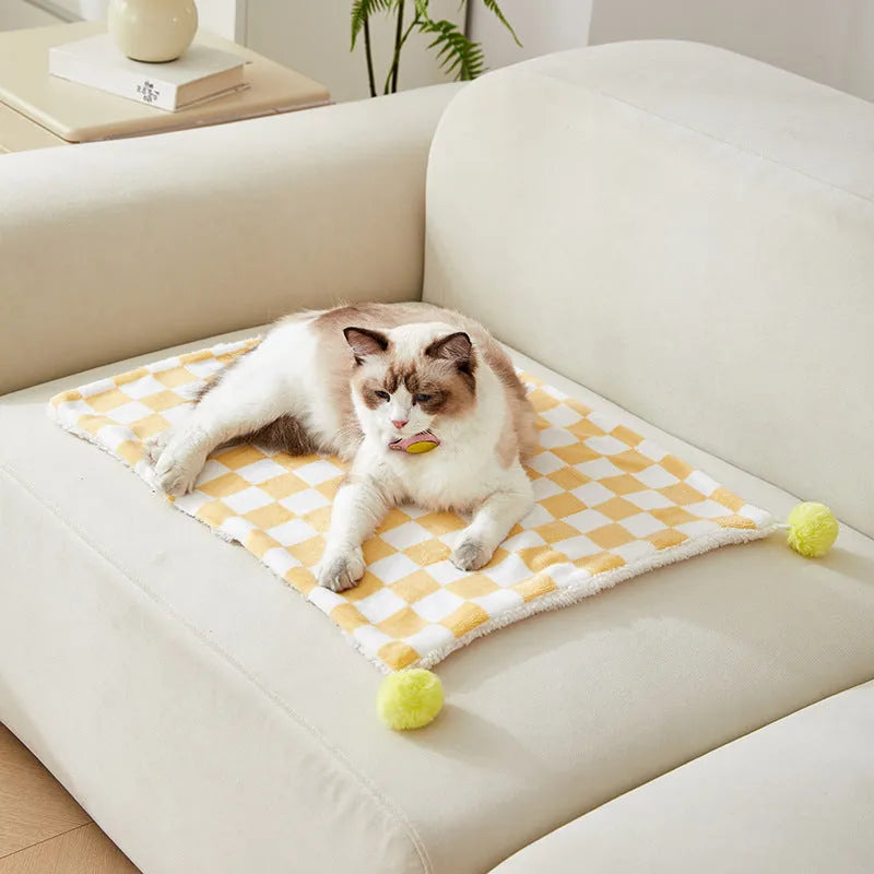Plush pet blanket with bright plaid pattern and fur ball decorations for cats and dogs