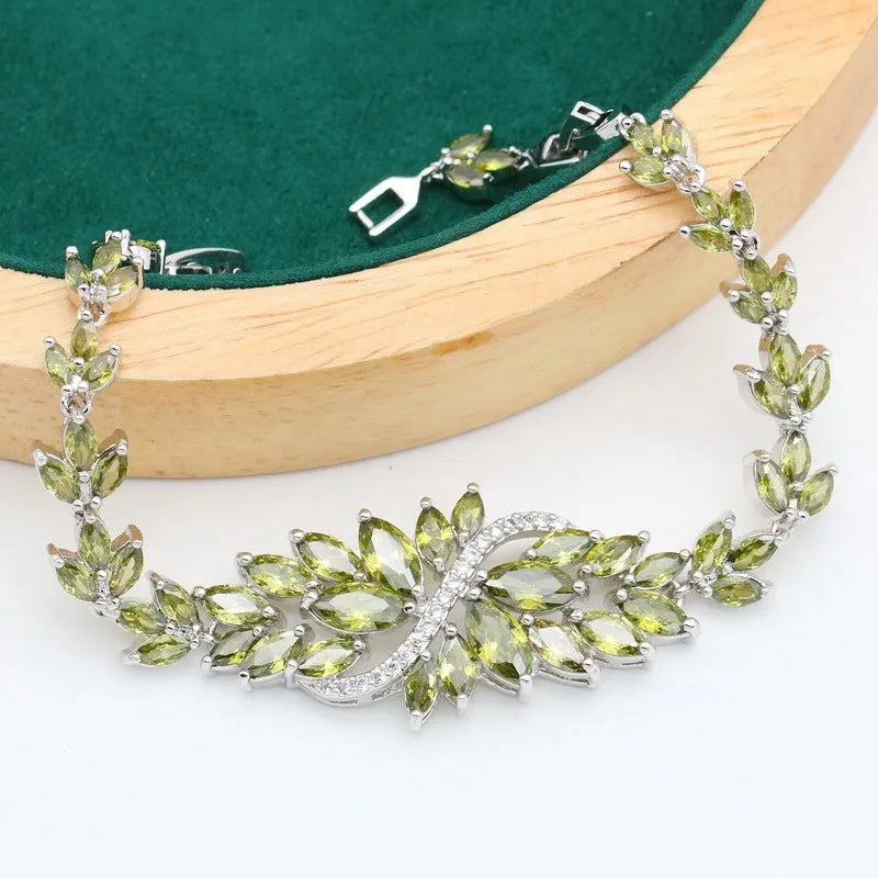 Retro style jewellery set showing necklace with floral pendant, bracelet, earrings, and ring in olive and purple colours.