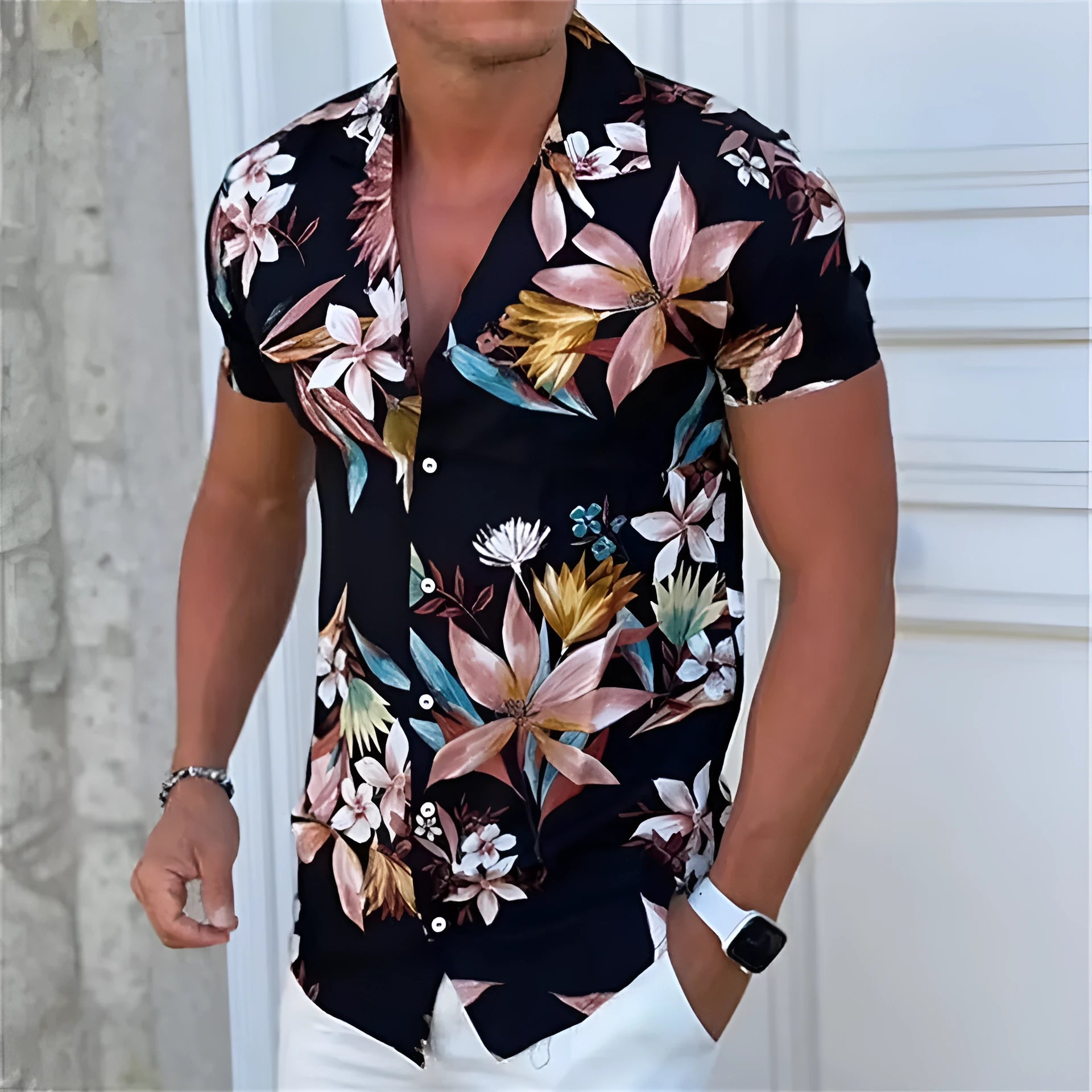 Man wearing a loose-fitting short sleeve shirt with a colourful floral pattern, cardigan style.