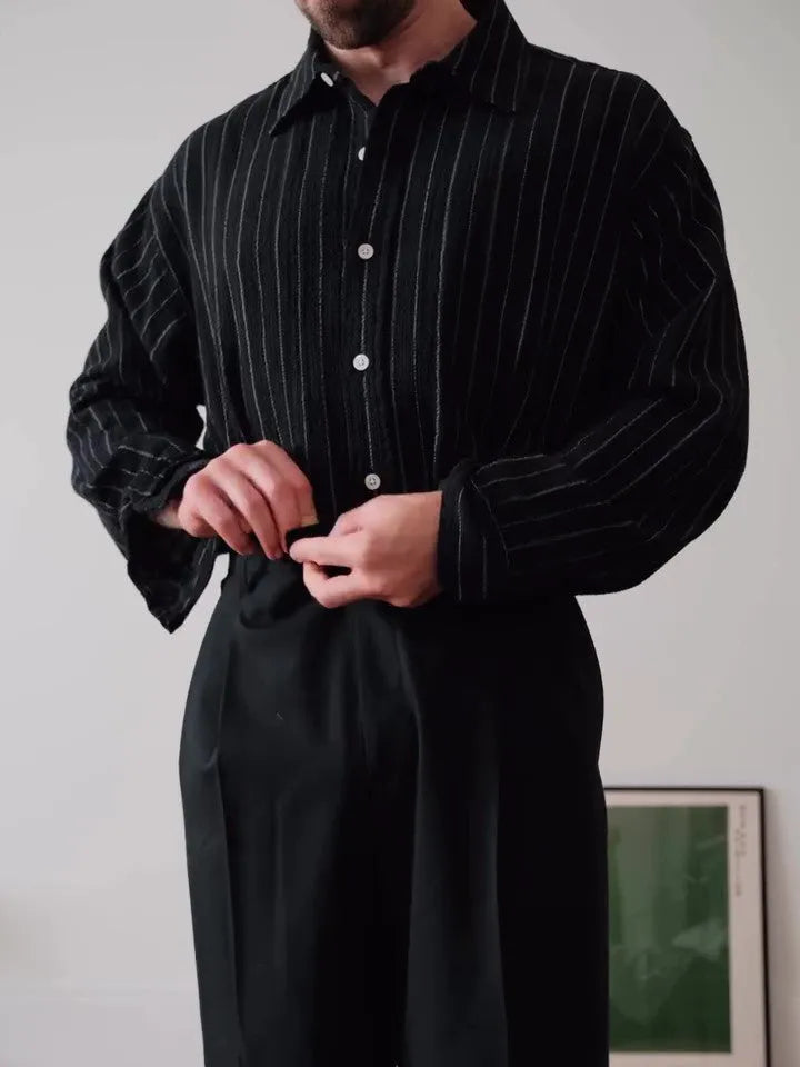 Black pinstriped button-down polyester shirt with a regular fit on a hanger.