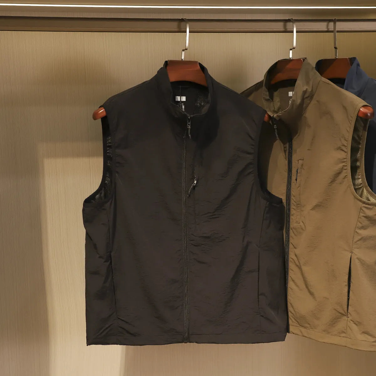 Men's straight-cut nylon vest cardigan in army green with side seam pockets, shown open as a lightweight layer.