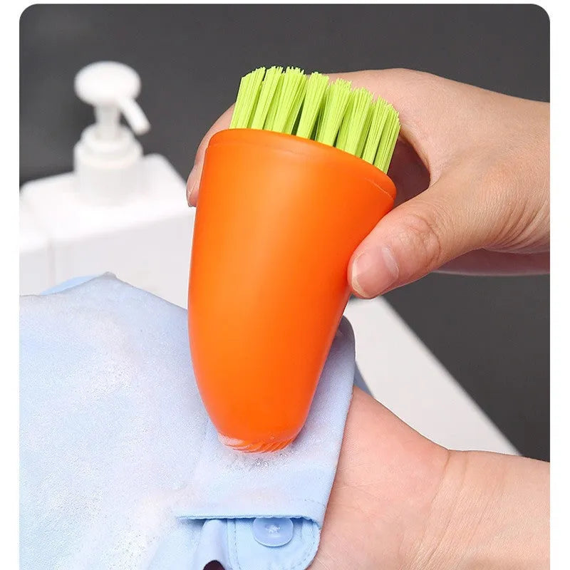 Carrot-shaped nylon kitchen cleaning brush on a white background, shown in orange and white colour options.