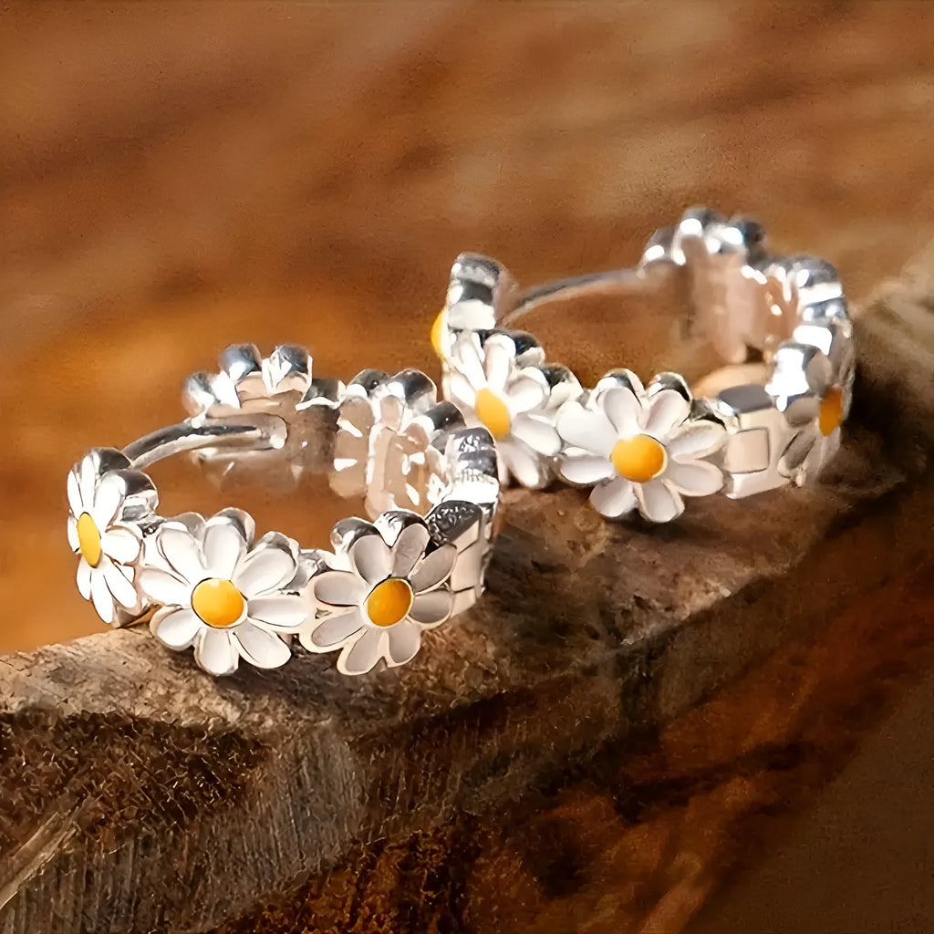 White electroplated daisy flower ring earrings with platinum gem settings on a copper base.