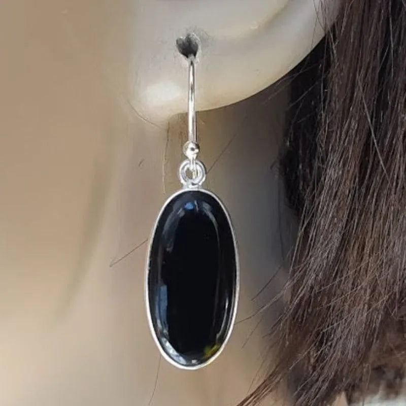 Women's earrings with black oval agate pendant and silver electroplated geometric Chinese style design.