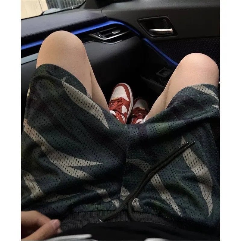 Men's straight leg camouflage shorts in cotton blend fabric on a hanger.