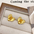 A pair of gold and silver retro-style flower earrings with petal details on a white background.