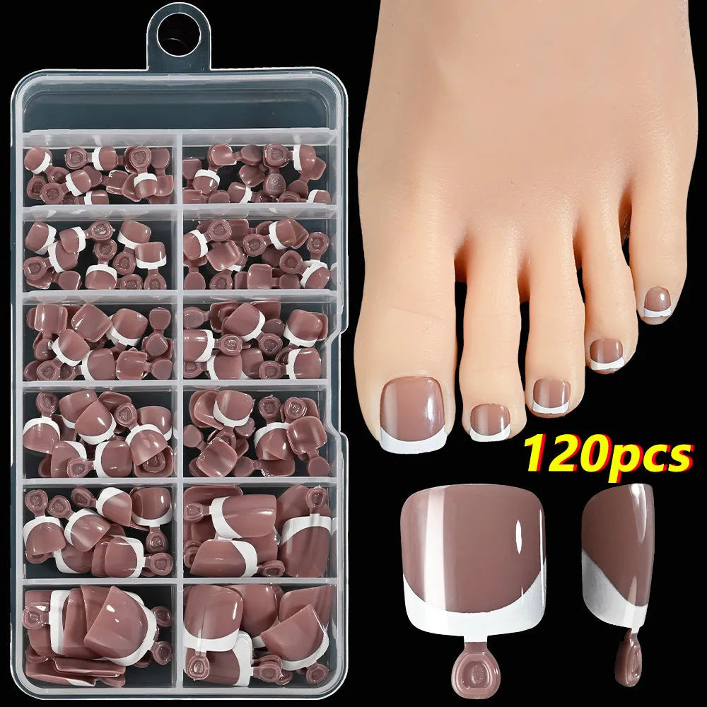 Box of 120 short square false toenails with French white tips, showing nine nude colour options from light to dark.