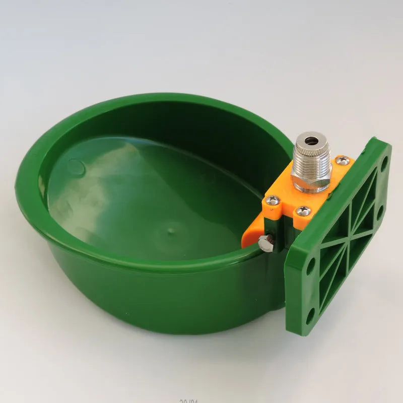 Green engineering plastic auto-drink water bowl for pigs and sheep on a farm.