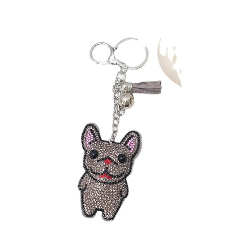 Close-up of a rhinestone and alloy French dog cartoon keychain with tassel pendant