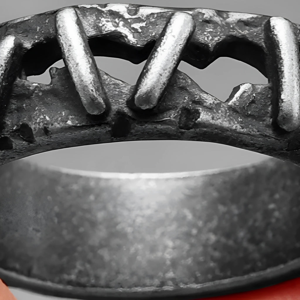 A stainless steel double ring with dark punk stitching style details, shown on a hand.