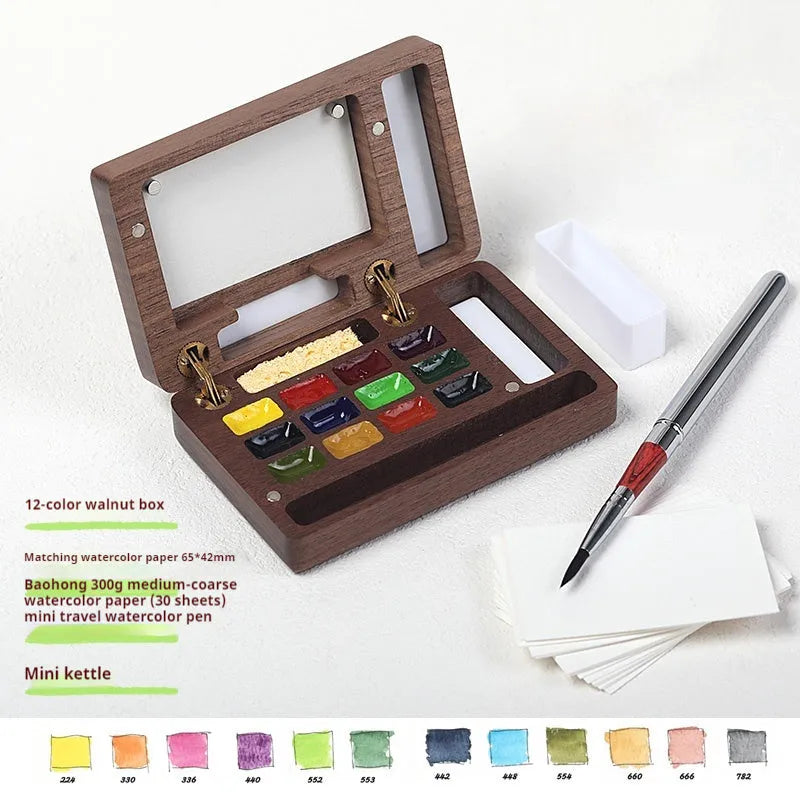 Mini wooden watercolour paint box open to show pigment pans inside.