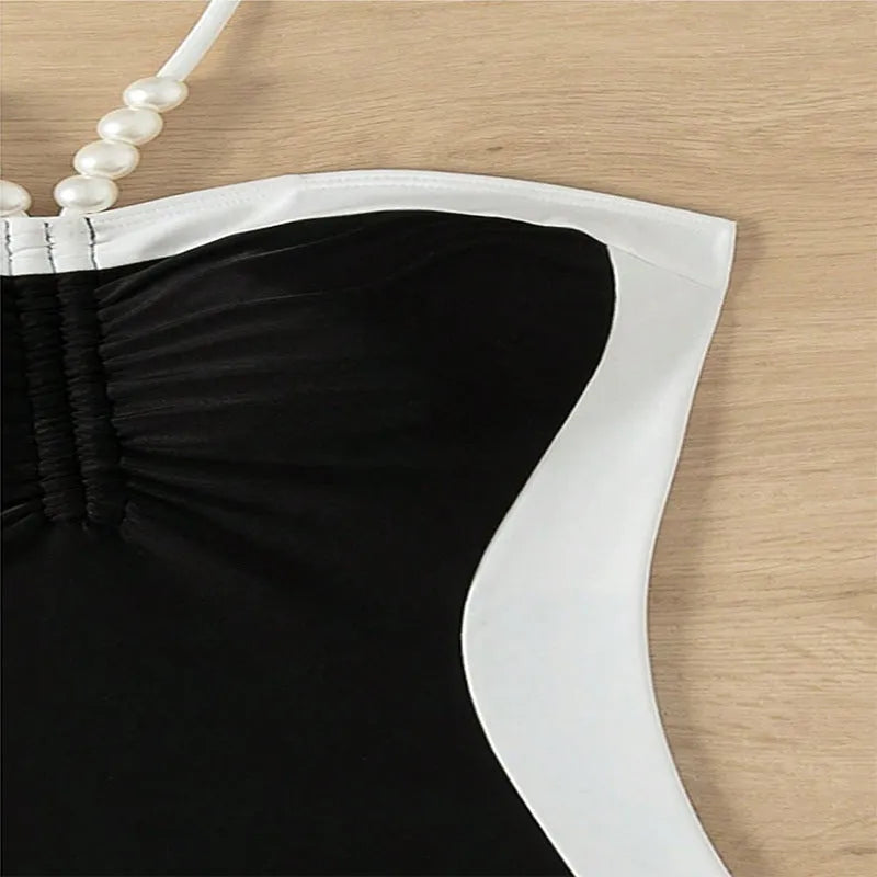 Women's black and white pearl spaghetti strap one-piece swimsuit with sleeveless slimming design.