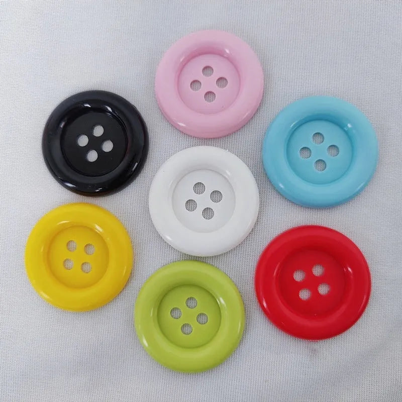 Plastic nylon oversize round sewing buttons in multiple colours showing four-hole design