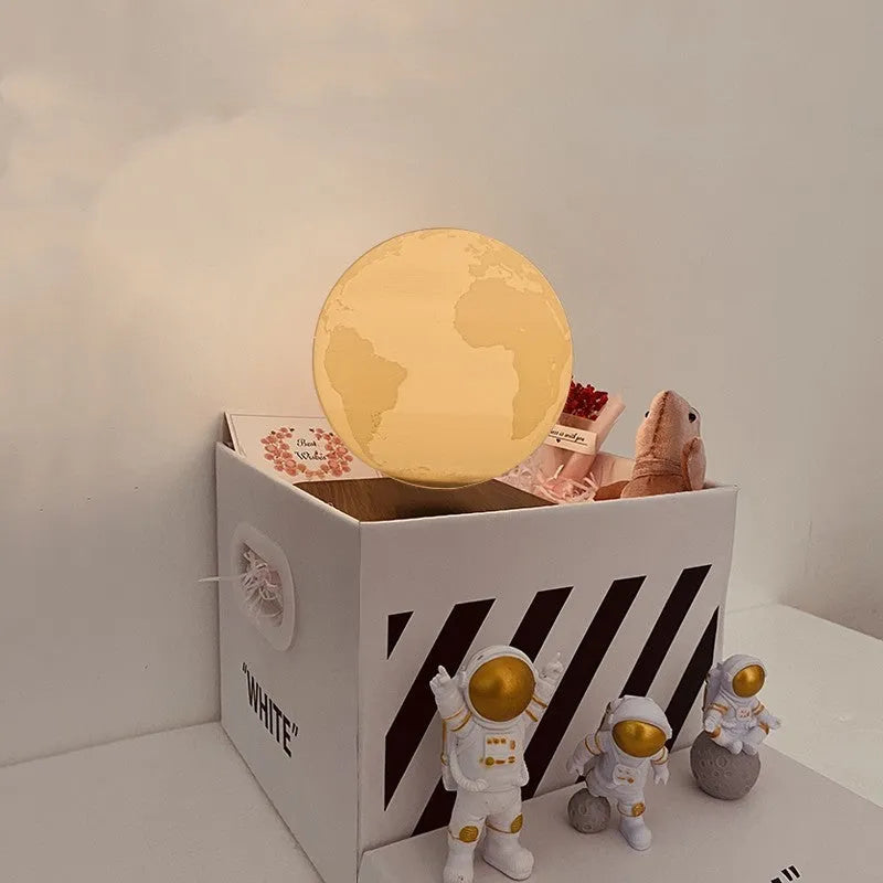 Maglev Moon Earth planet night light floating above base with LED glow, next to astronaut figurines.