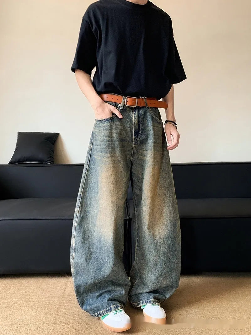 Men modelling retro blue distressed wide-leg jeans with machete detailing and a slimming fit.